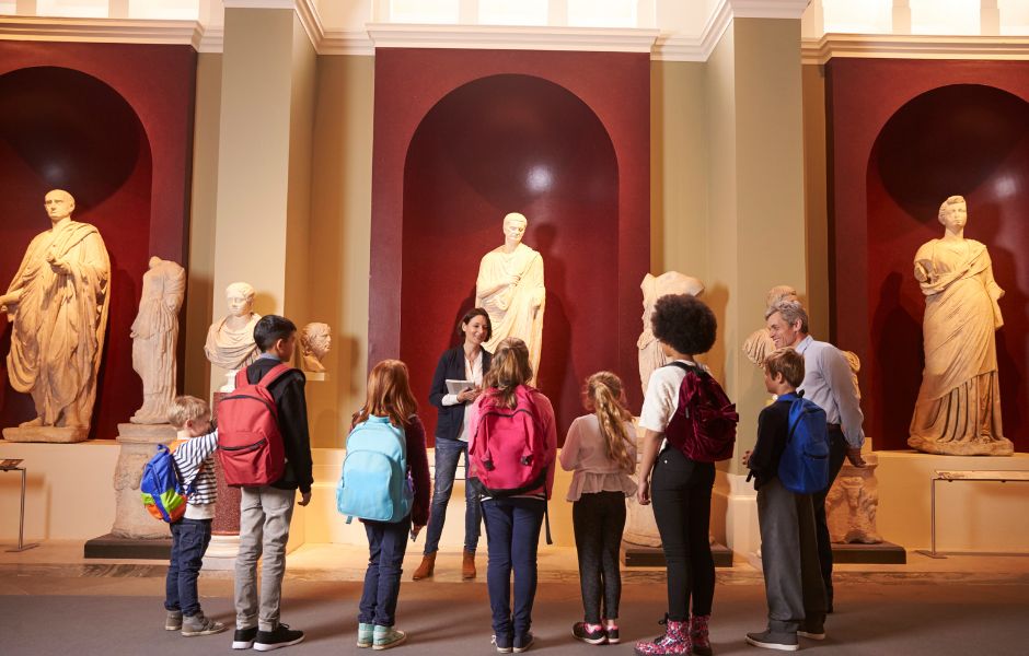 Groupe d'élèves dans un musée écoutant une guide