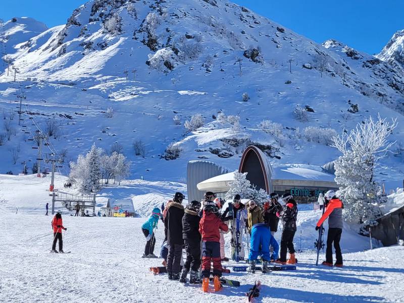 groupe d'élèves en ski devant un paysage enneigé